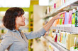 © Robert Kneschke - Frau trifft Entscheidung beim Shopping in Drogerie
