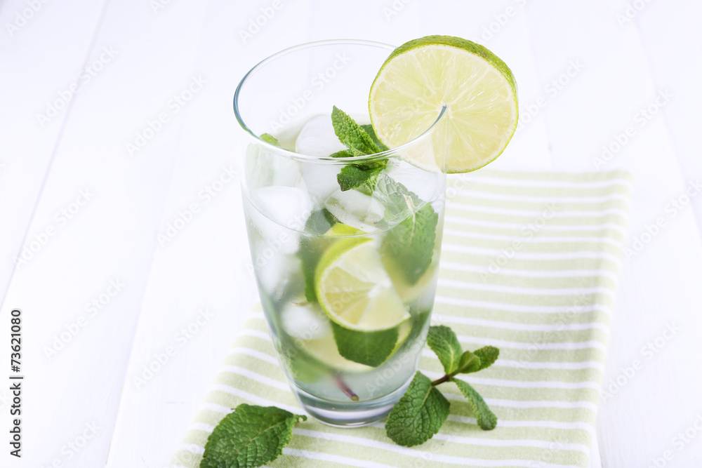 Lemonade in glass on napkin on bright background