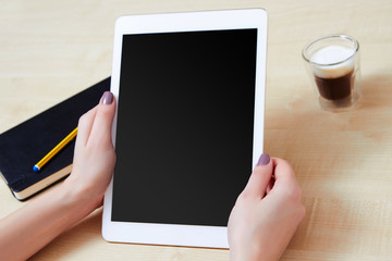 Hands holding a tablet pc with blank screen in portrait mode