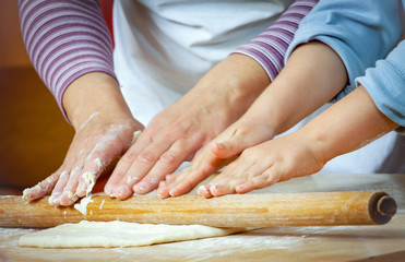 Little girl making pizza for lunch with her mother