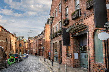 Wall Mural - Cobbled Street Lined with Rebovated Brick Buildings