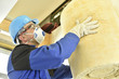 Man holding glasswool rolls in new built house