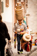 Traditional hats vendor laughing and walking in San Miguel de Al