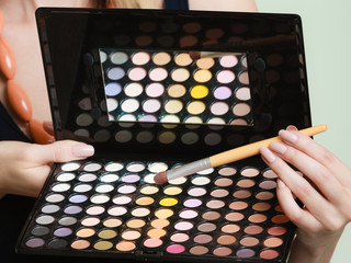 Wall Mural - colorful eyeshadows palette, makeup brush in female hand