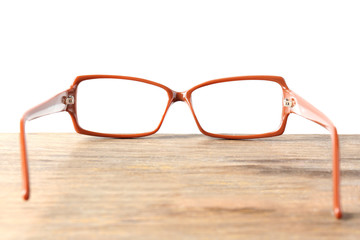 Poster - Eye glasses on wooden table on white background