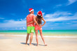 © el.rudakova - young couple in santa hats laughing on tropical beach. new year