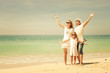 © altanaka - Happy  family  walking on the beach at the day time.