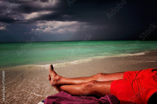 Lonely men lying on the beach in Cuba Wallpaper Mural