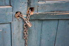 Old Blue Wooden Door Locked With A Chain And Padlock
