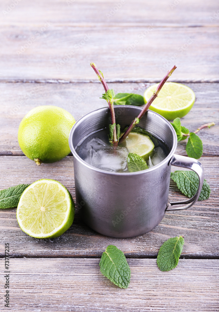 Lemonade in metal cup on wooden background