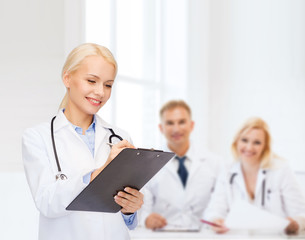 Poster - smiling female doctor with clipboard