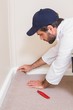 © WavebreakMediaMicro - Handyman laying down a carpet