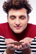 © Drobot Dean - Casual man with curly hair holding a coffee beans