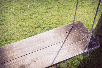 Wall Mural - playground swing hanging in green grass field