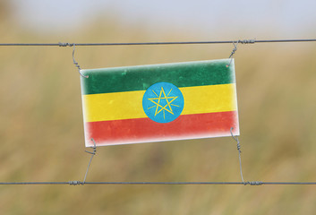 Border fence - Old plastic sign with a flag