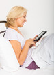 © JackF - mature woman with eBook laying in her bed