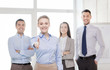 © Syda Productions - smiling businesswoman in office with team on back