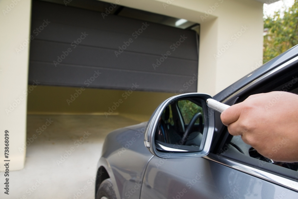 driver opens the garage with remote control - obrazy, fototapety, plakaty 