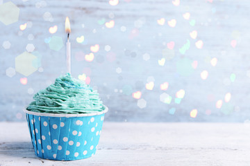 Delicious birthday cupcake on wooden table