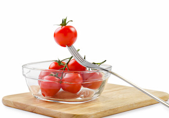 Wall Mural - Cherry tomatoes in a glass bowl and fork  with clipping path