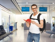 smiling student with backpack and book at airport