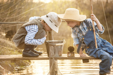 Boy fishes on a bridge on the lake