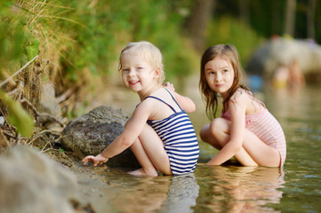 Two little sisters having fun in a river