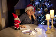 © Denizo - little boy writing wish list at home in the living room
