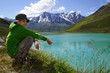 Kind mit Hut sitzt als Wanderer am Rifflsee in Tirol