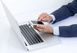© littlestocker - Businessman hands holding mobile phone  with laptop computer