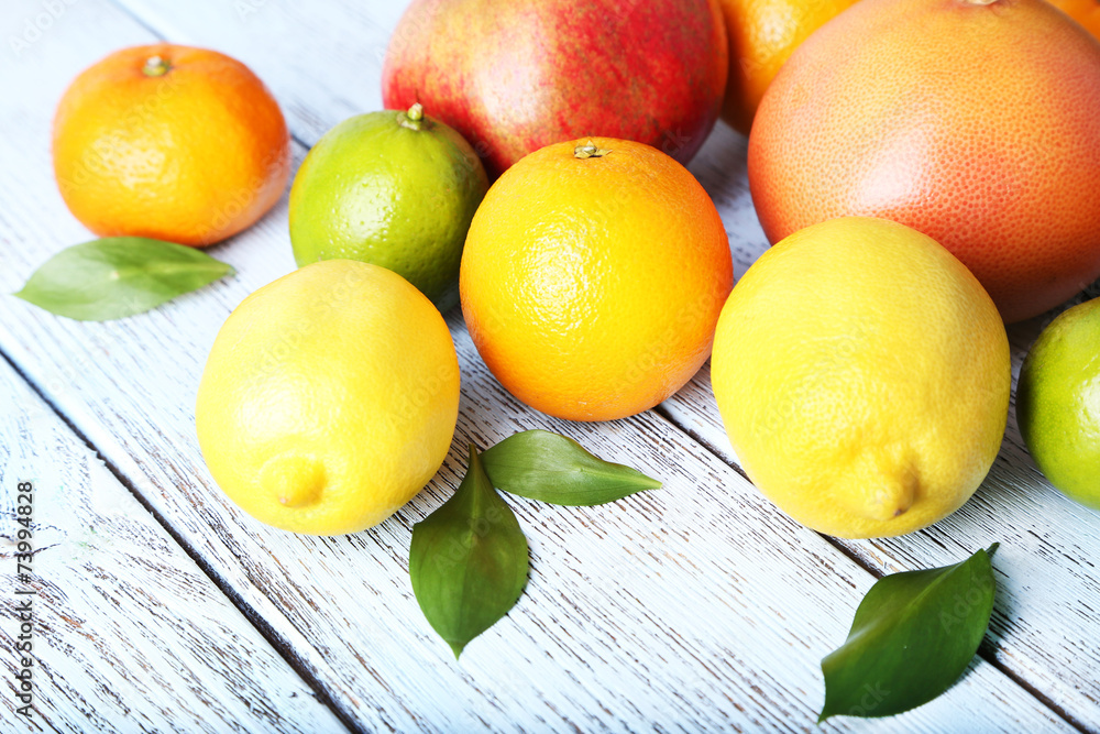 Ripe citrus with green leaves on wooden background
