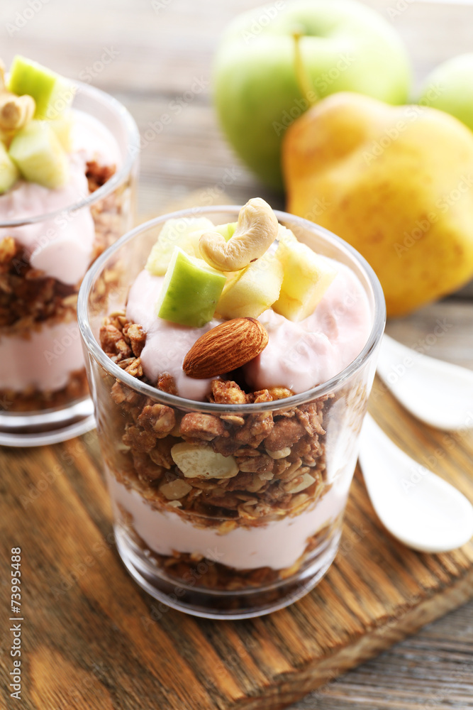 Healthy layered dessert with muesli and berries on table
