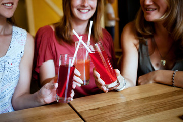 friends with fruit  lemonade and cocktails having fun in the bar