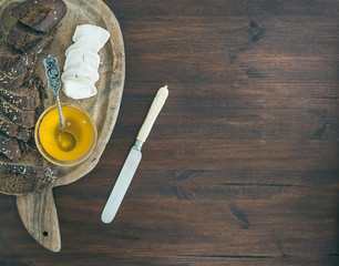 Wall Mural - Fresh dark baguette cut in slices, goat brie cheese and honey on