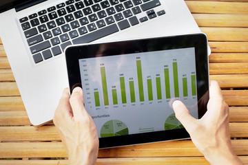 hands of farmer with tablet with infographics on the screen