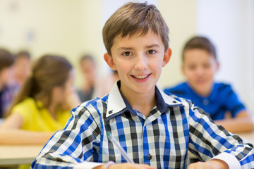 group of school kids writing test in classroom