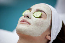 Beautiful Young Woman Receiving Facial Mask Of Cucumber In Beaut