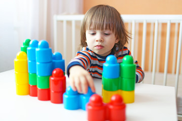 happy 2 years toddler plays plastic blocks