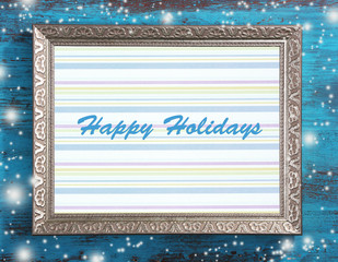 Christmas greeting card with frame on wooden background