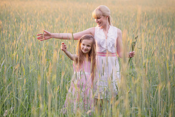 Woman with girl in field of wheat