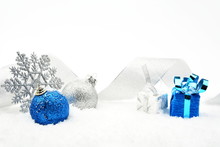 Silver And Blue Christmas Glittering Baubles With Ribbon On Snow