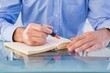 © WavebreakMediaMicro - Hands highlighting text in book