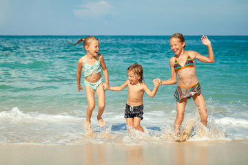 Sticker - happy kids playing on beach at the day time