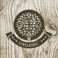 Organic product badge with tree on wooden texture. Vector illust