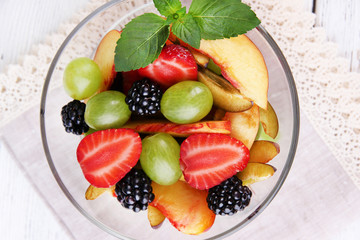 Wall Mural - fresh tasty fruit salad on wooden table