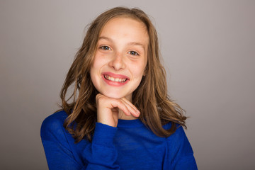 Wall Mural - Happy young girl with hand on chin