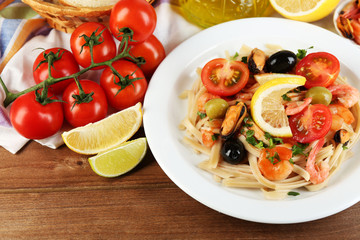 Tasty pasta with shrimps, mussels, black olives and tomato