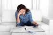 © Wordley Calvo Stock - young woman worried at home in stress accounting with calculator