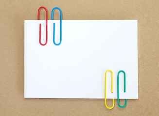 color metal paper clip and blank white paper note