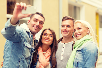 Canvas Print - group of smiling friends making selfie outdoors